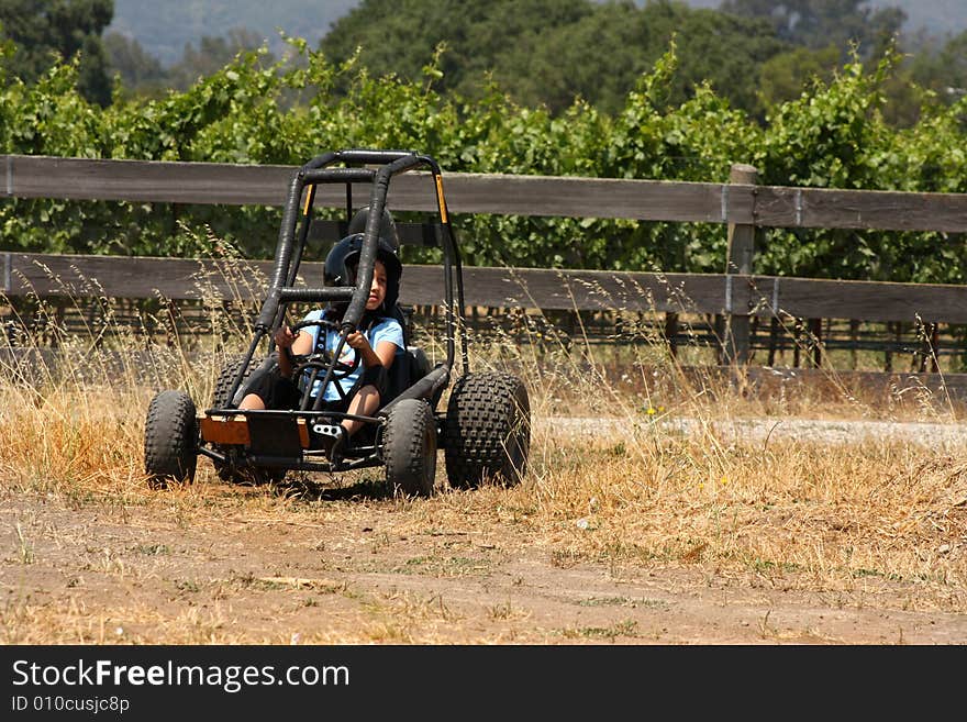 Child on a go kart on dirt road. Child on a go kart on dirt road