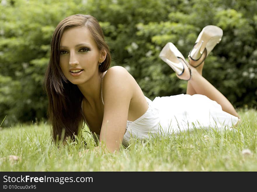 Beautiful and sexy brunette girl on the grass in the park. Beautiful and sexy brunette girl on the grass in the park