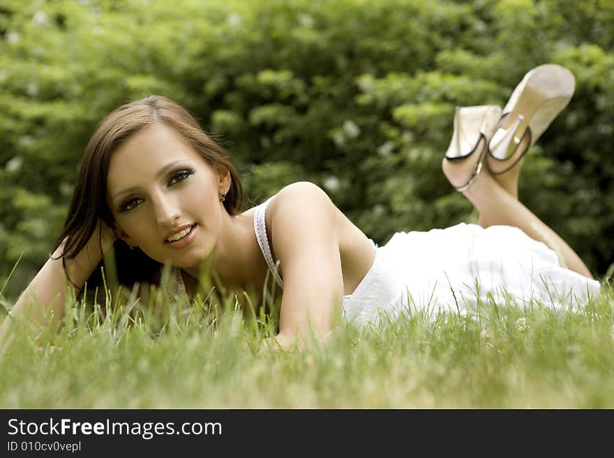 Beautiful and sexy brunette girl on the grass in the park. Beautiful and sexy brunette girl on the grass in the park