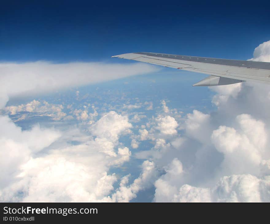 Airplane wing above clouds and horizon. Airplane wing above clouds and horizon