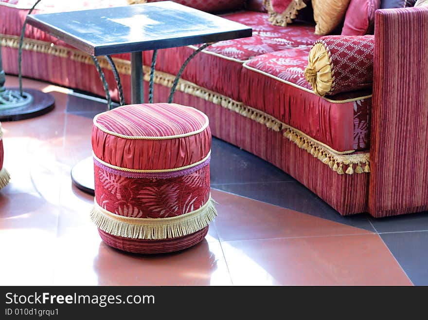 Fragment of oriental furniture at cafe, red pouffe