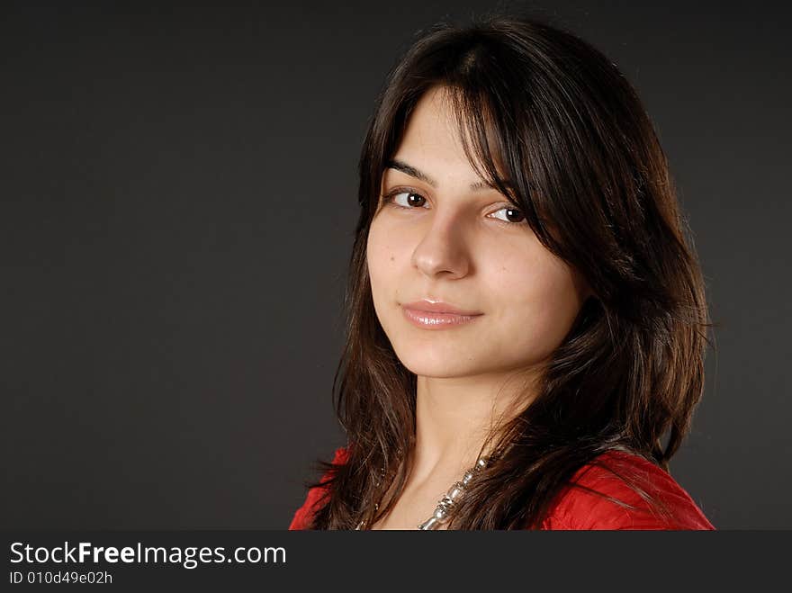 Brunette girl in red dress with dark-grey background