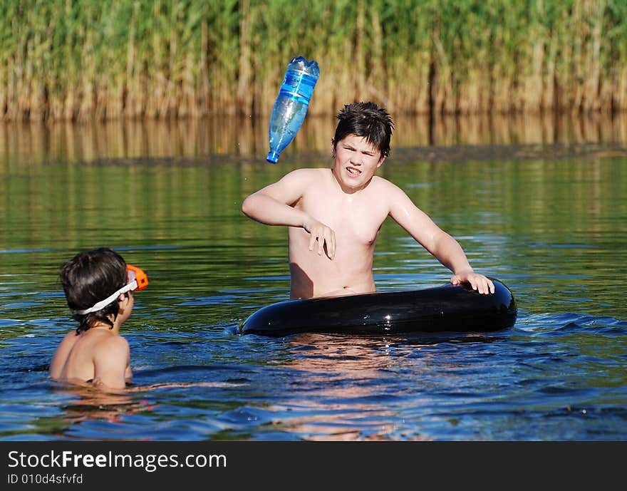 The boy playing with his friend in a small Lithuanian lake. The boy playing with his friend in a small Lithuanian lake.