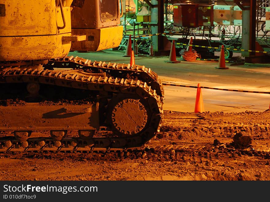 Industrial construction site abstract with track rolls foreground by night