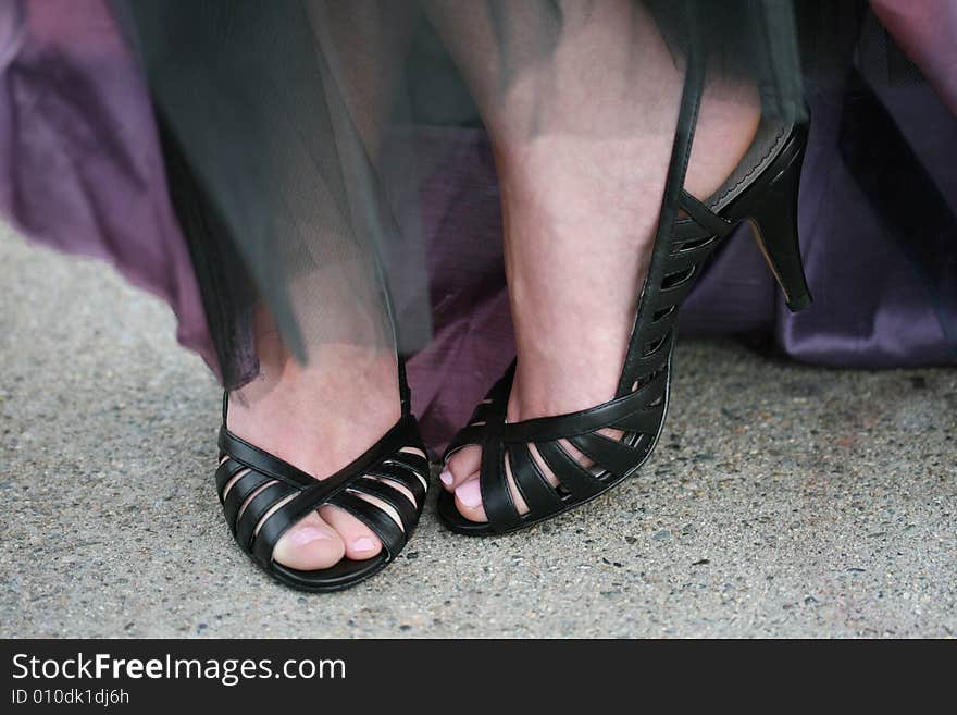 A woman in black high heels and an evening gown