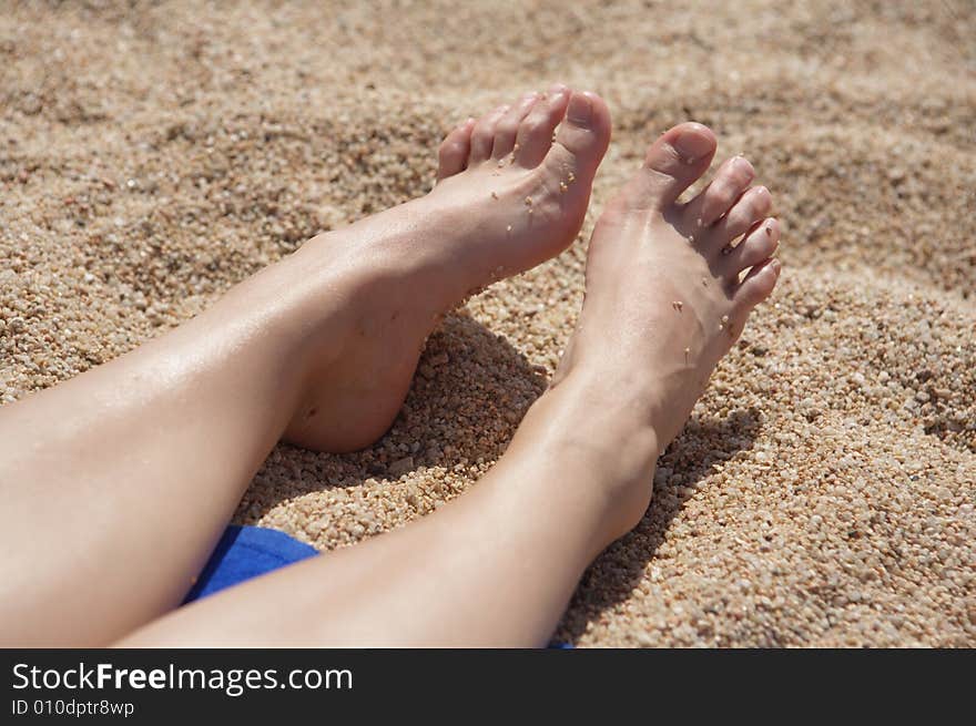 A photo of women's feet on the sand