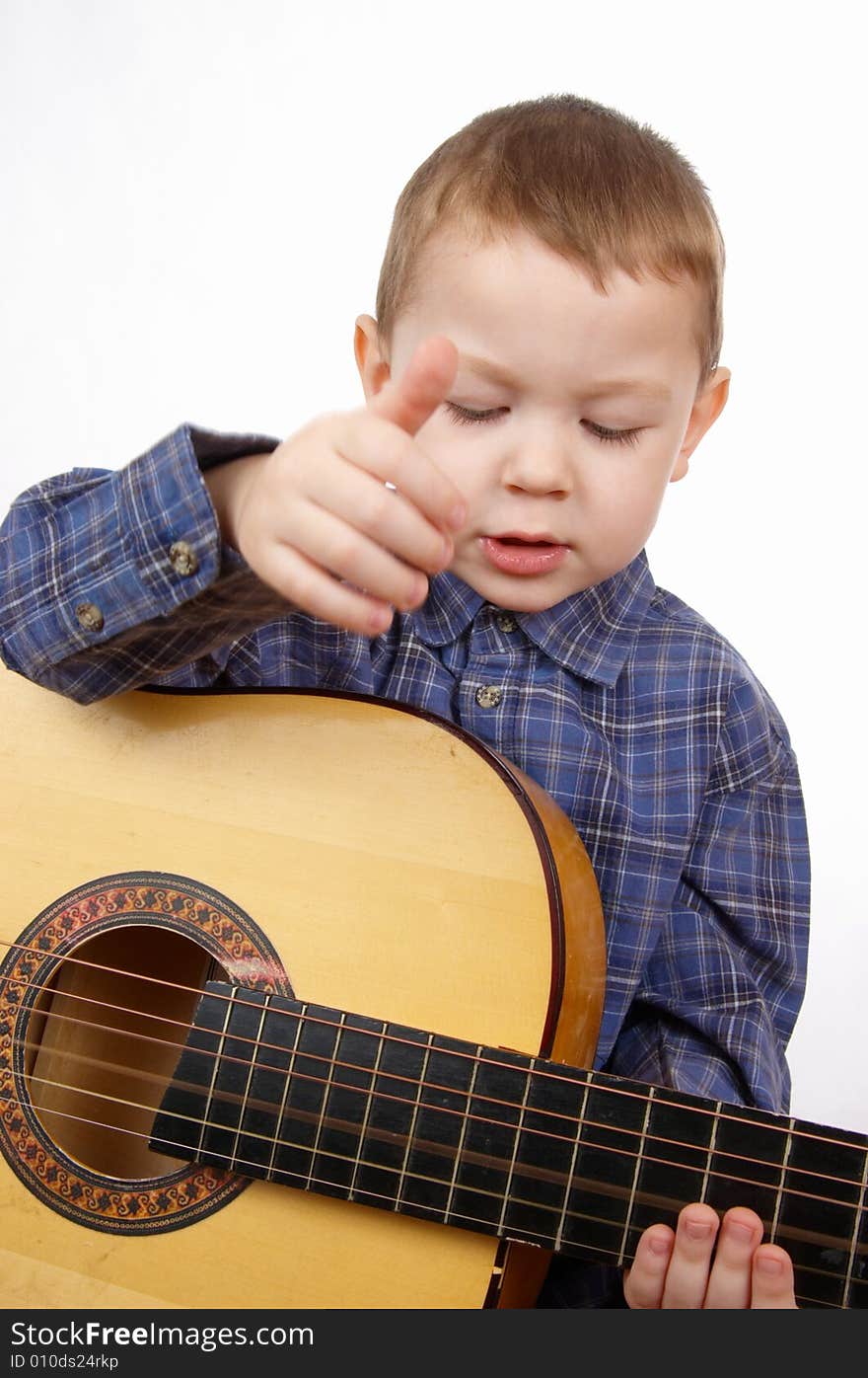 The boy plays an acoustic guitar