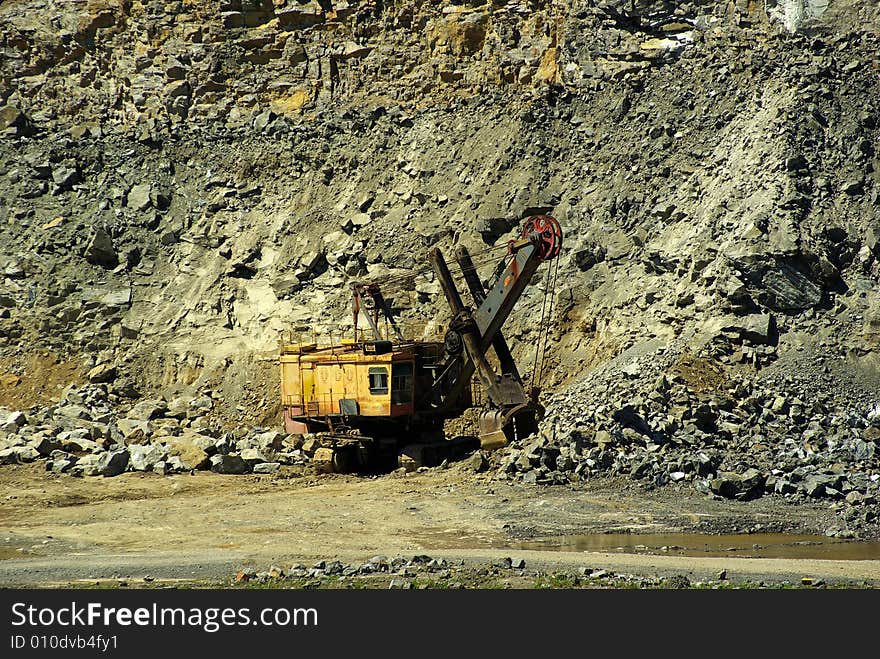 Ekskavator loads a stone on a truck