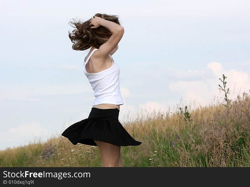 A beautiful girl dancing on the field. A beautiful girl dancing on the field