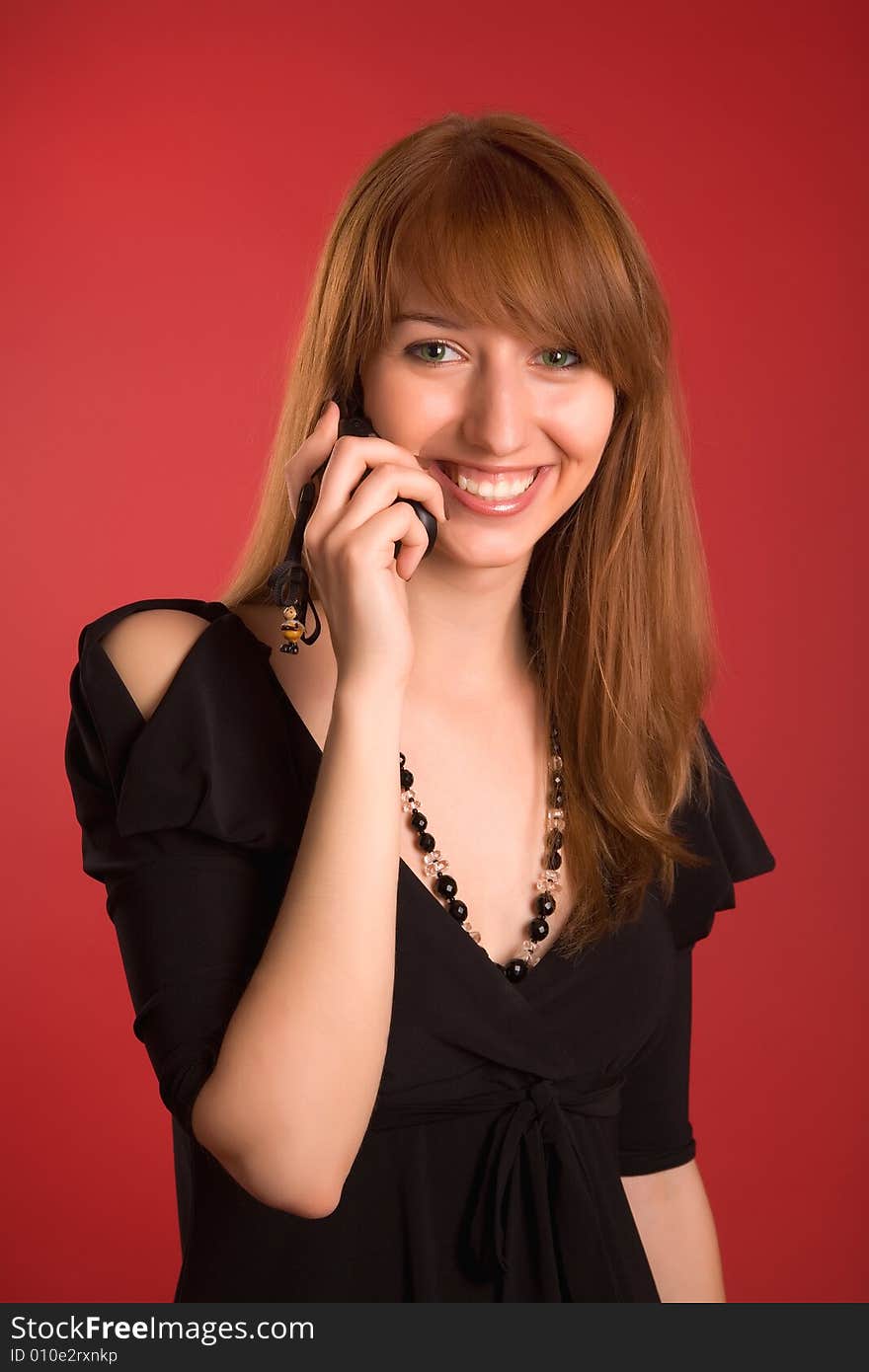 Smiling girl in evening dress with mobile phone