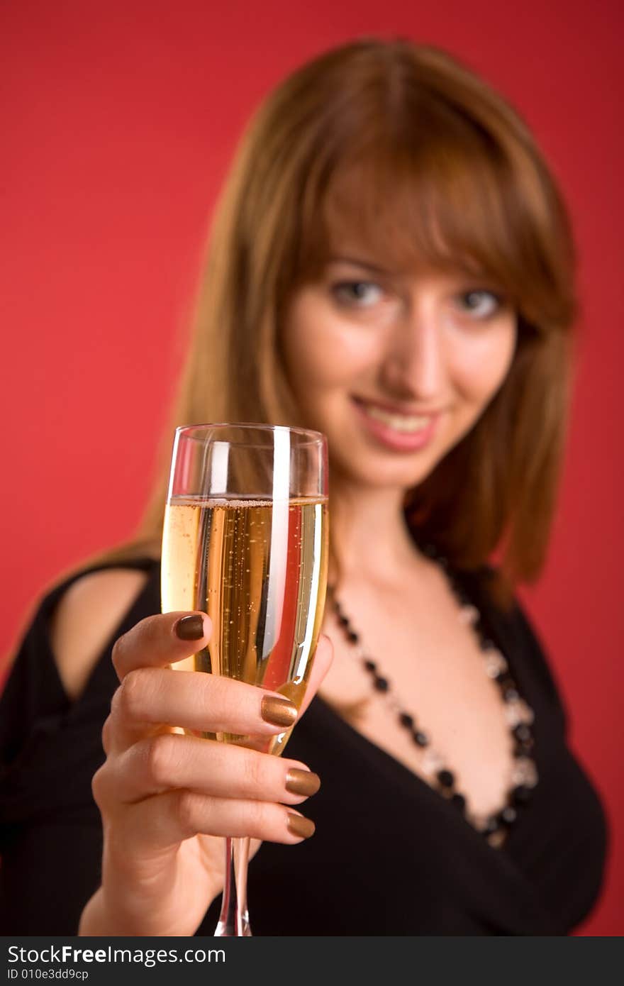 Girl with champagne, focus on glass, isolated on red background. Girl with champagne, focus on glass, isolated on red background