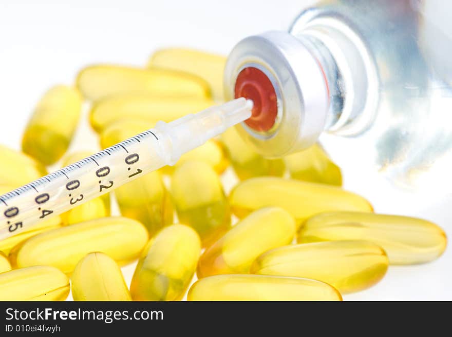 Three yellow pills, a syringe and medicine bottle. Three yellow pills, a syringe and medicine bottle.