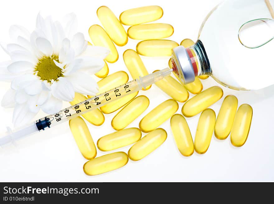 Three yellow pills, a syringe and medicine bottle. Three yellow pills, a syringe and medicine bottle.