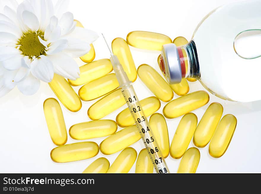 Three yellow pills, a syringe and medicine bottle. Three yellow pills, a syringe and medicine bottle.