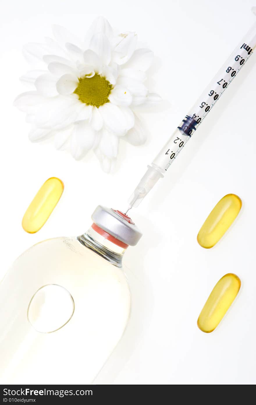 Three yellow pills, a syringe and medicine bottle. Three yellow pills, a syringe and medicine bottle.