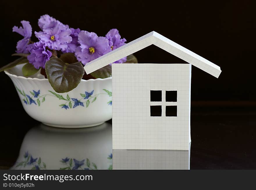 Paper house from the notebook sheet against the black background. Paper house from the notebook sheet against the black background