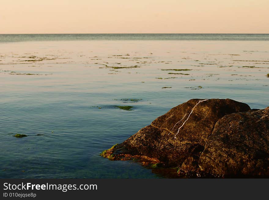 Sea on sunset with rocks in water. Sea on sunset with rocks in water