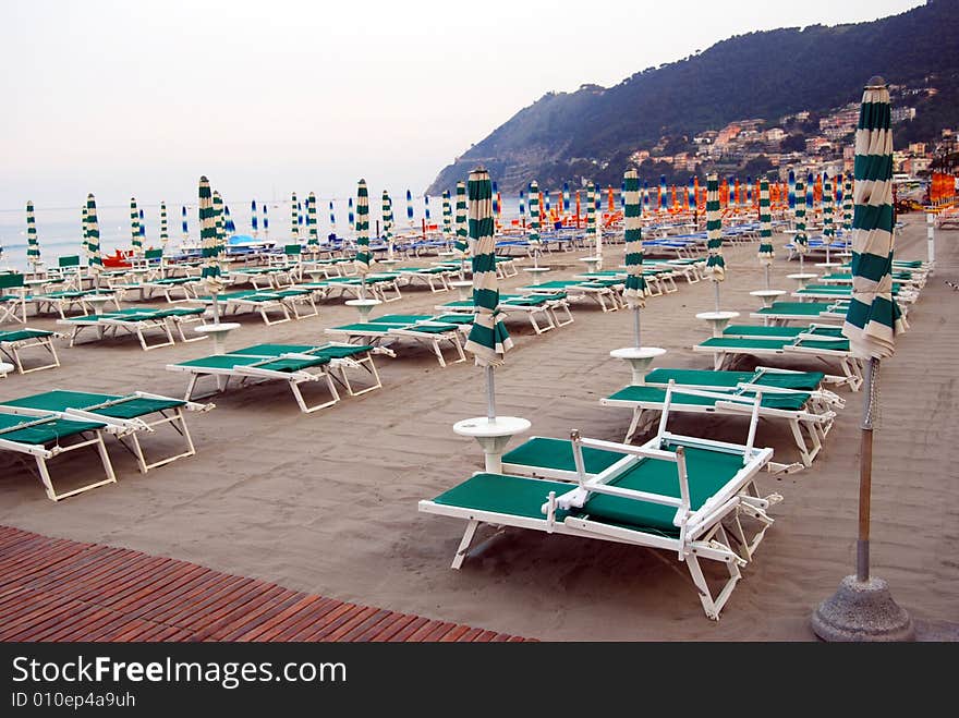 Closed umbrellas on the beach in Laigueglia, Liguria in Italy