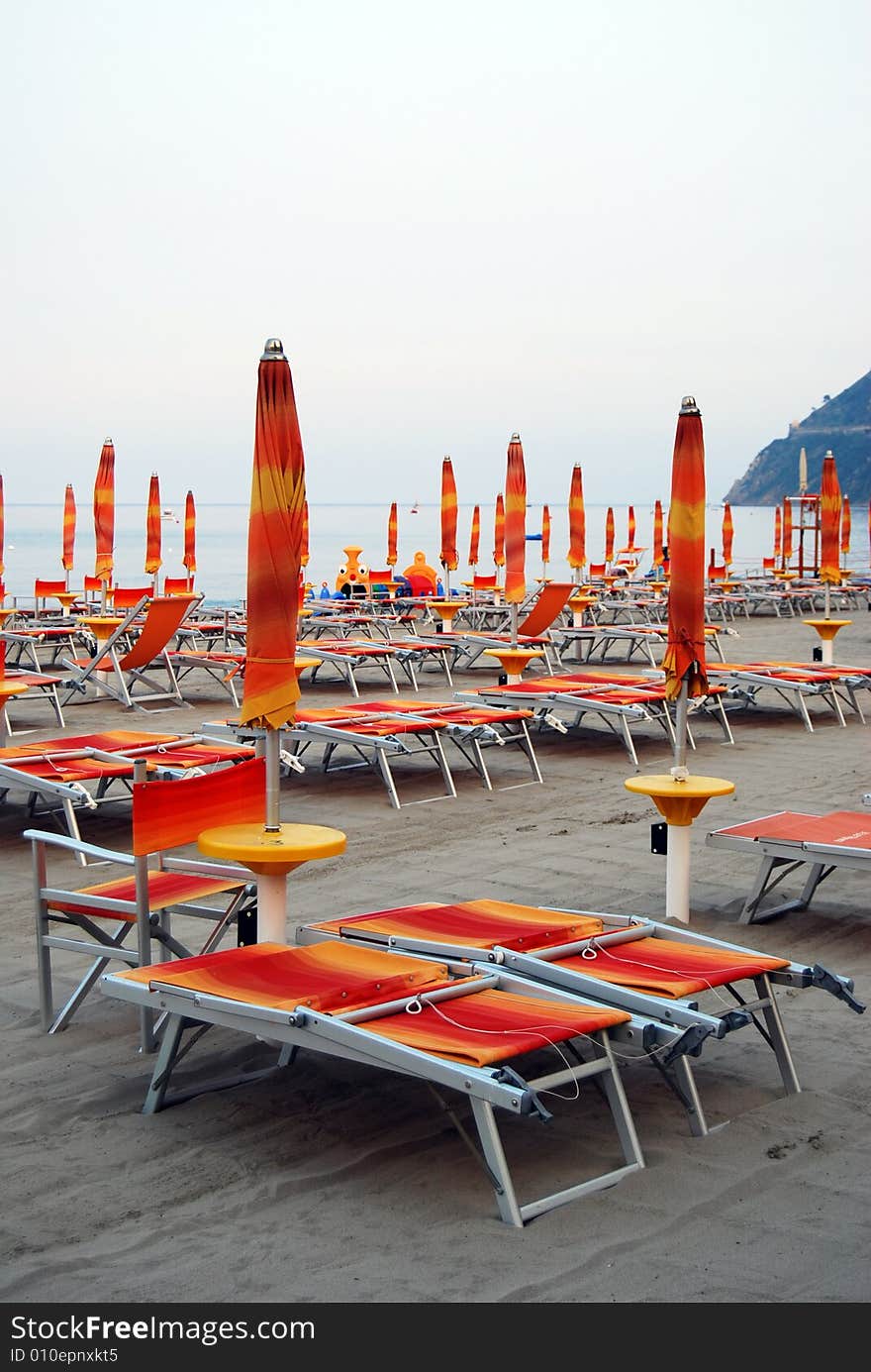 Closed umbrellas on the beach in Laigueglia, Liguria in Italy