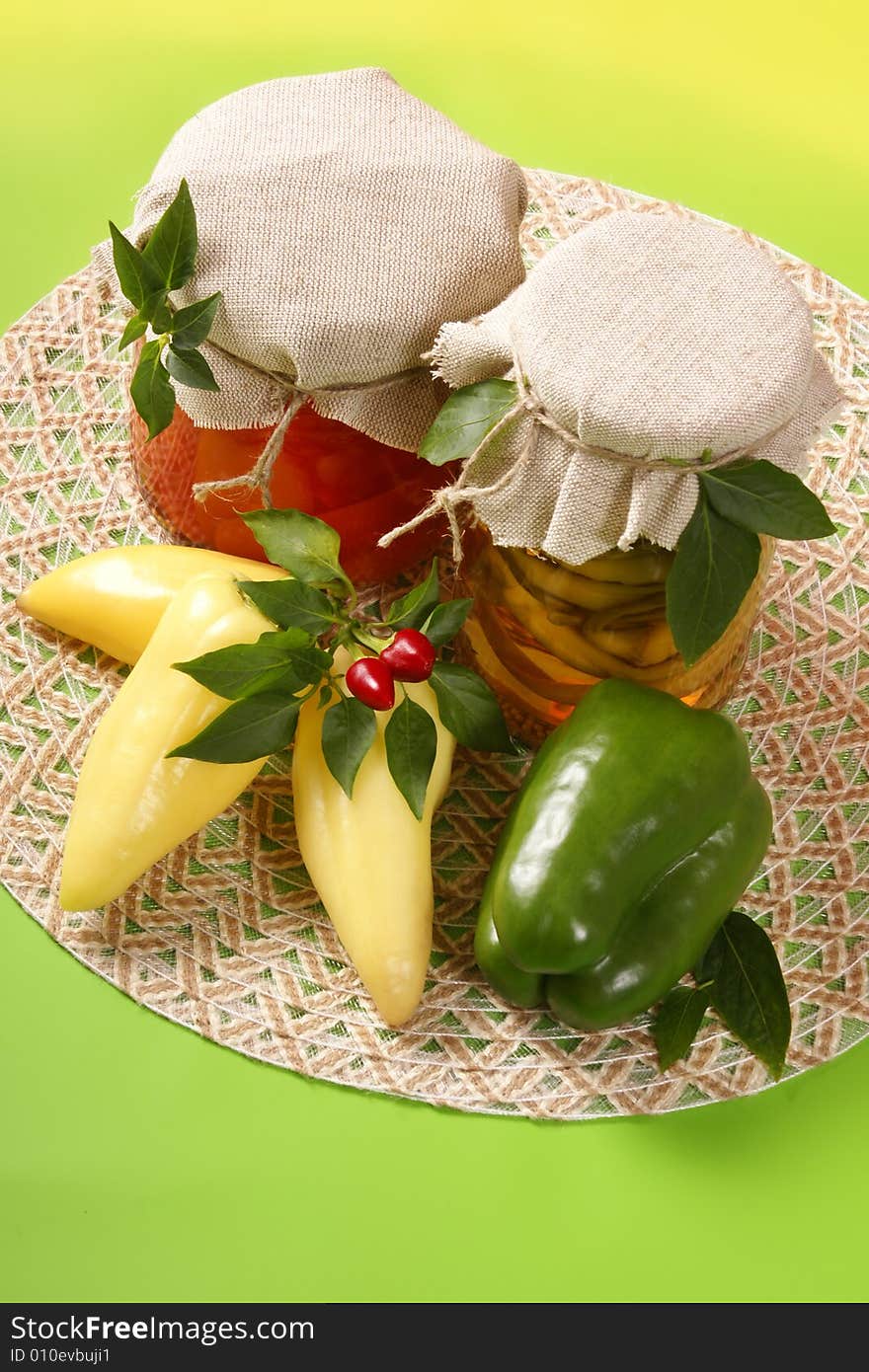 Marinated vegetables in glass jar, with fresh paprikas