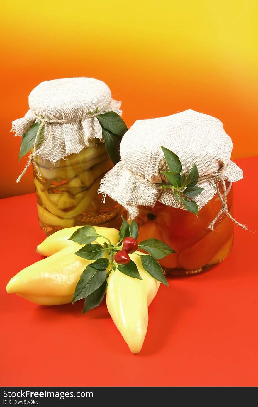 Marinated vegetables in glass jar, with fresh paprikas