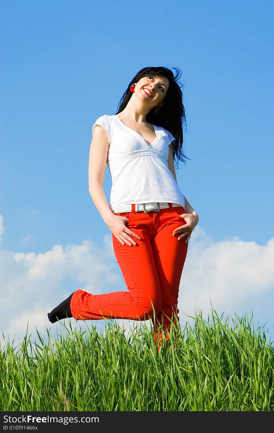 Pretty woman on green grass and sky background