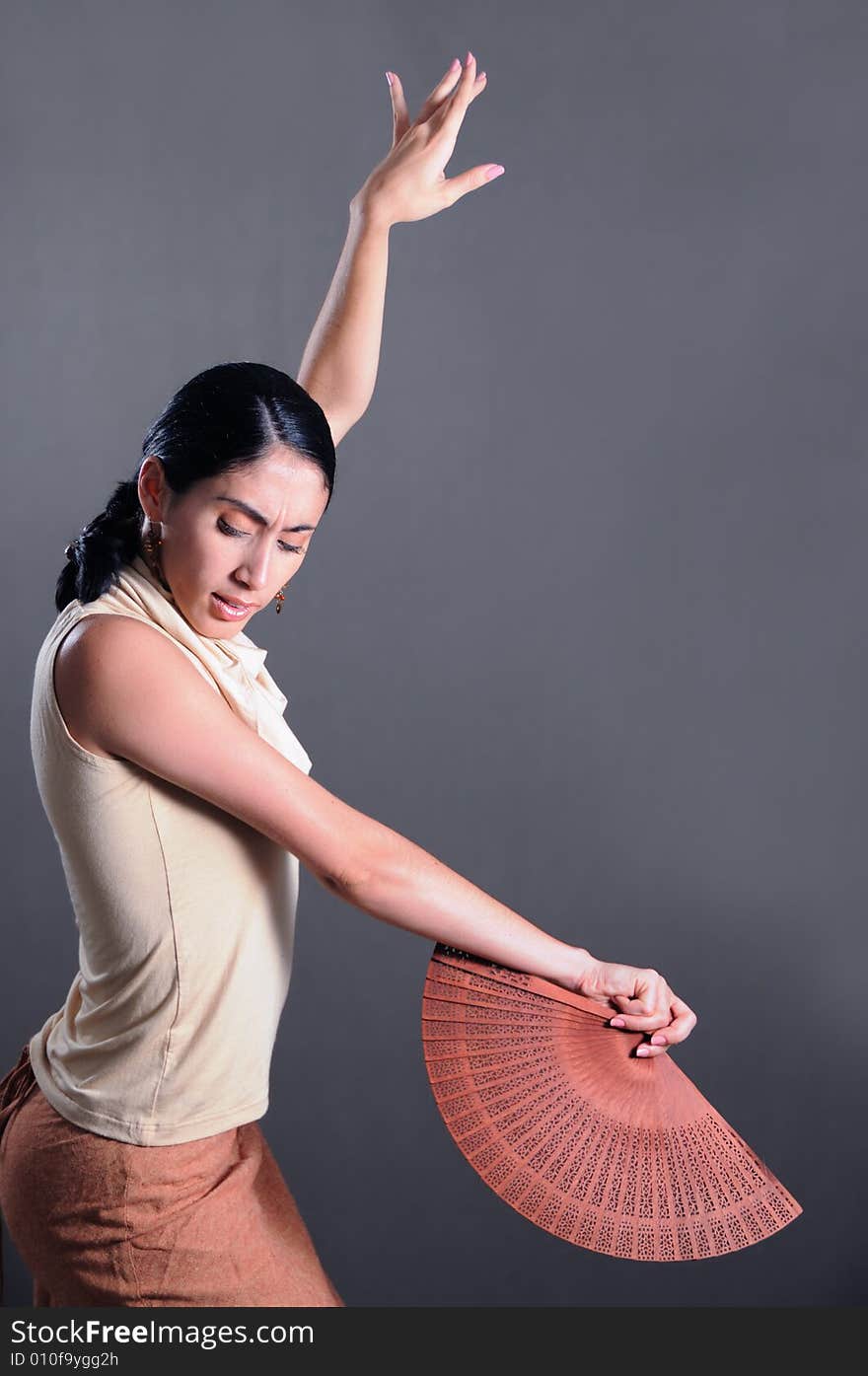 Portrait of hispanic flamenco dancer woman with traditional fan