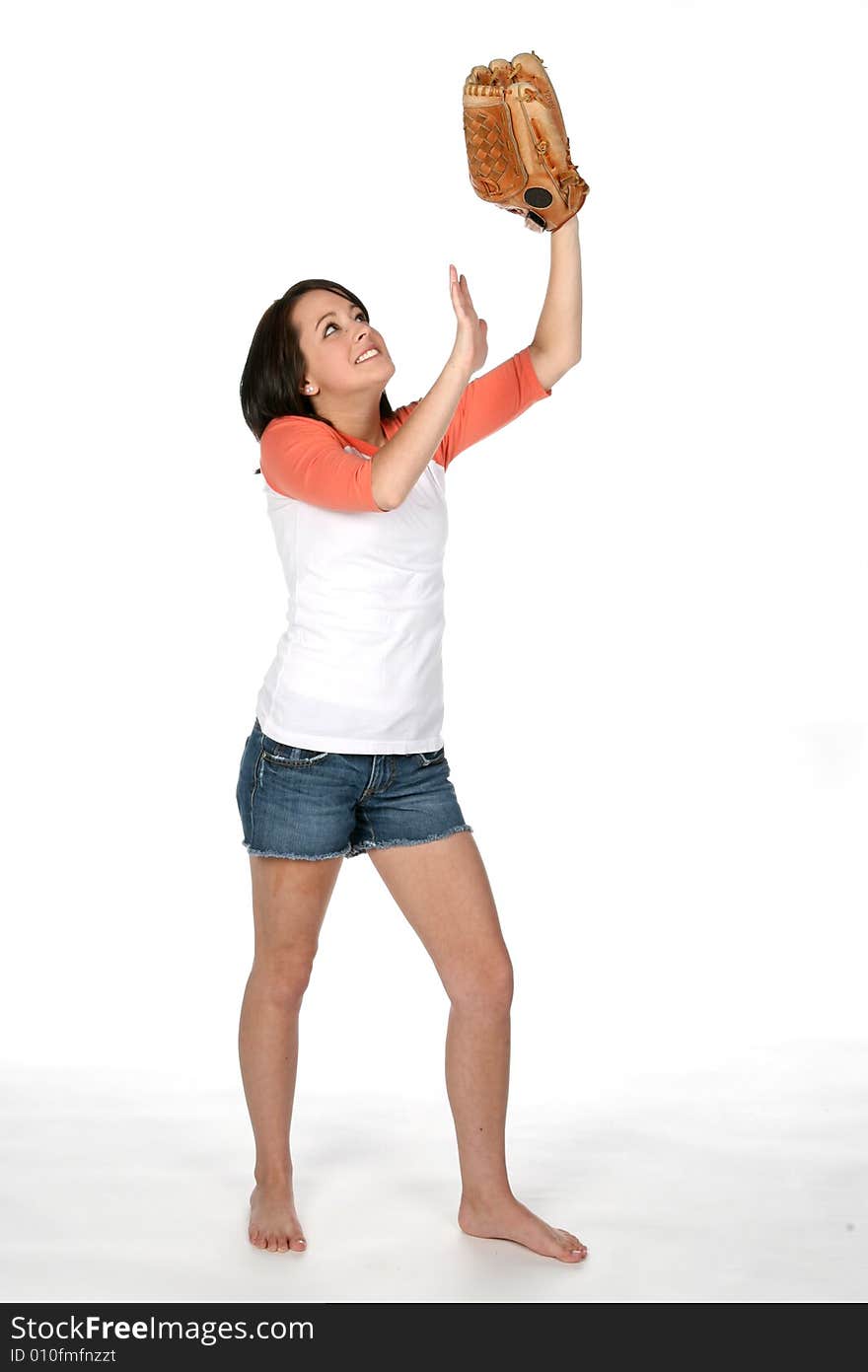 Teenage girl holding softball glove in the air as if catching a ball