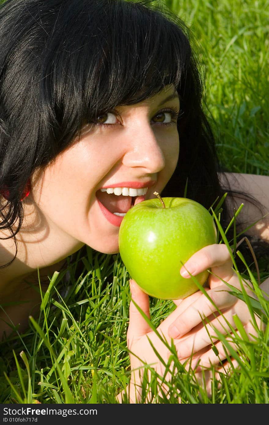 Pretty woman eating green apple