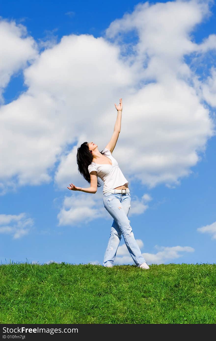 Expressive woman dancing on green grass