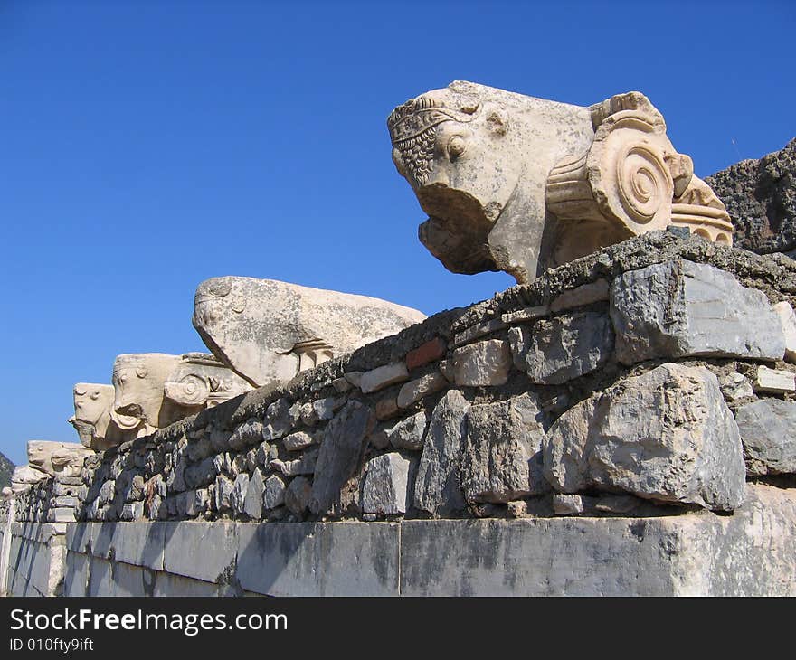 Old Roman carvings, high atop an ancient wall in the city of Ephesus, in early morning light. Old Roman carvings, high atop an ancient wall in the city of Ephesus, in early morning light.