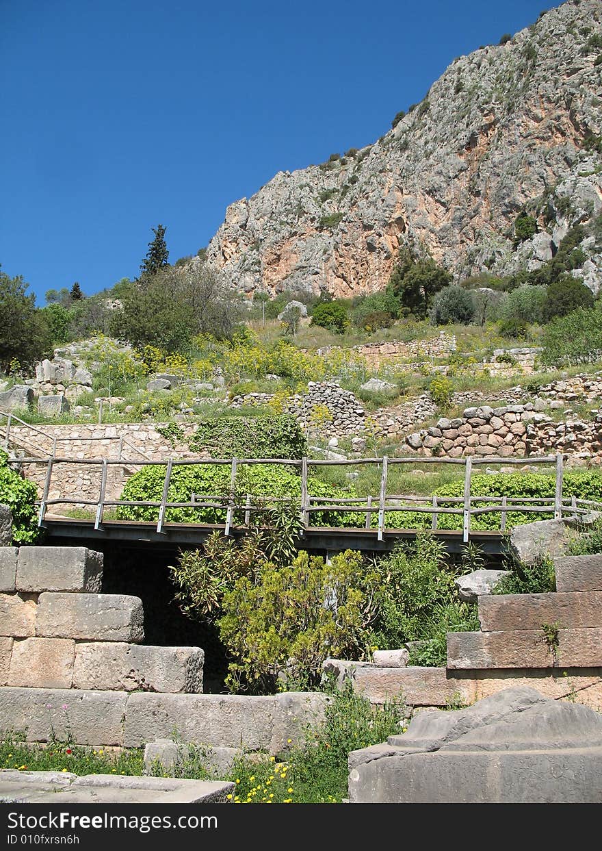 Old stone walls, and modern bridge combine to make an amazing image. Having existed for thousands of years, this famous place - the center of the universe for the ancient civilization of the Greeks, rests high atop the mountain, near the gulf of Corinth and the Peloponnese in Greece. Old stone walls, and modern bridge combine to make an amazing image. Having existed for thousands of years, this famous place - the center of the universe for the ancient civilization of the Greeks, rests high atop the mountain, near the gulf of Corinth and the Peloponnese in Greece.