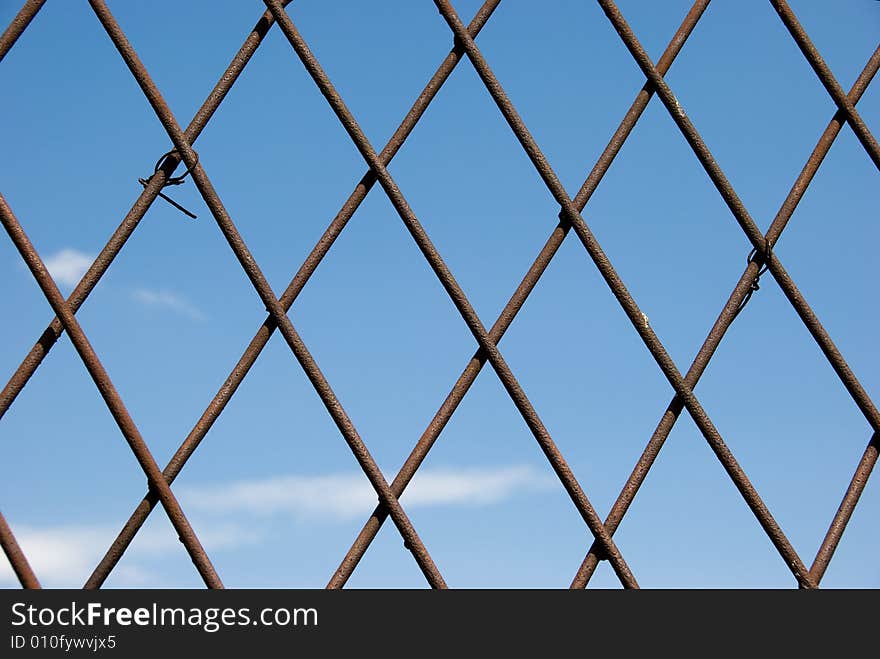 Rusty grate over sky background