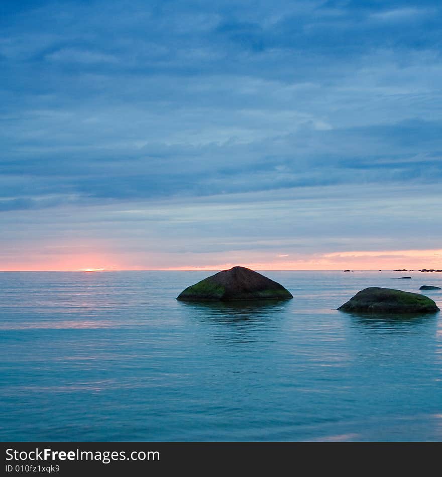 Two stones in the sea. Dusk.