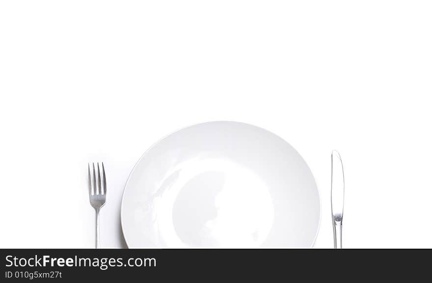 Knife and fork silverware with white plate on white background. Knife and fork silverware with white plate on white background