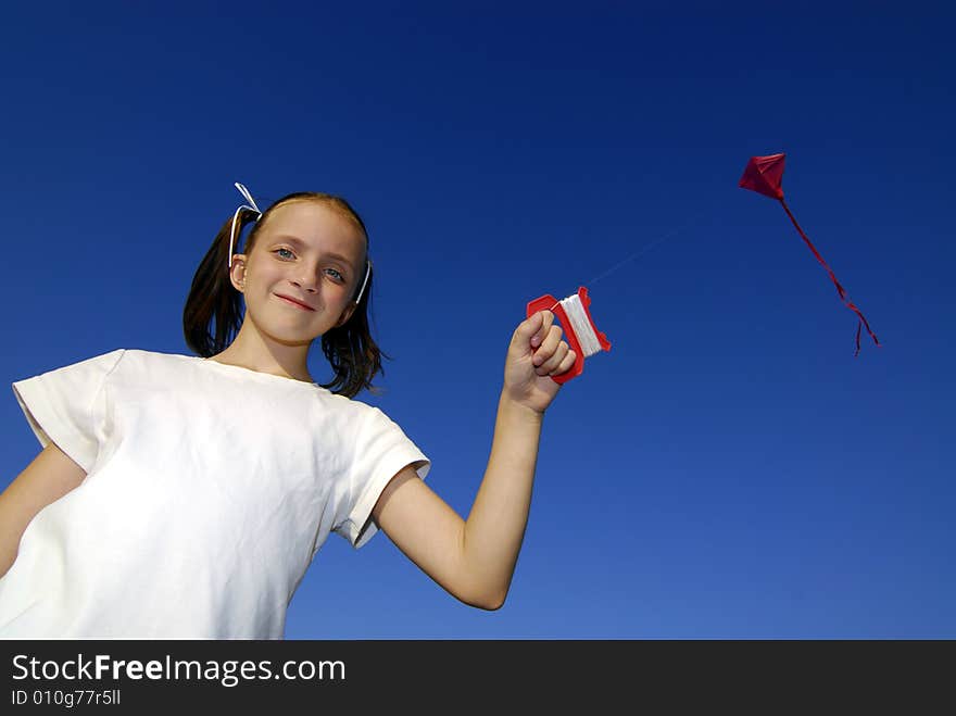 Girl flying a kite in a park with blue sky