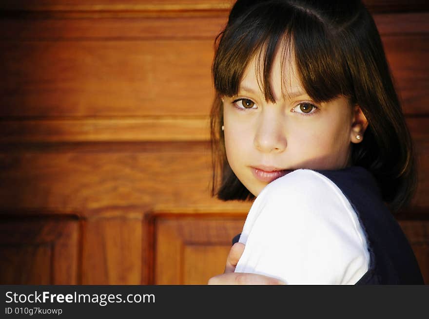 Girl infront of a door looking forward over her shoulder. Girl infront of a door looking forward over her shoulder