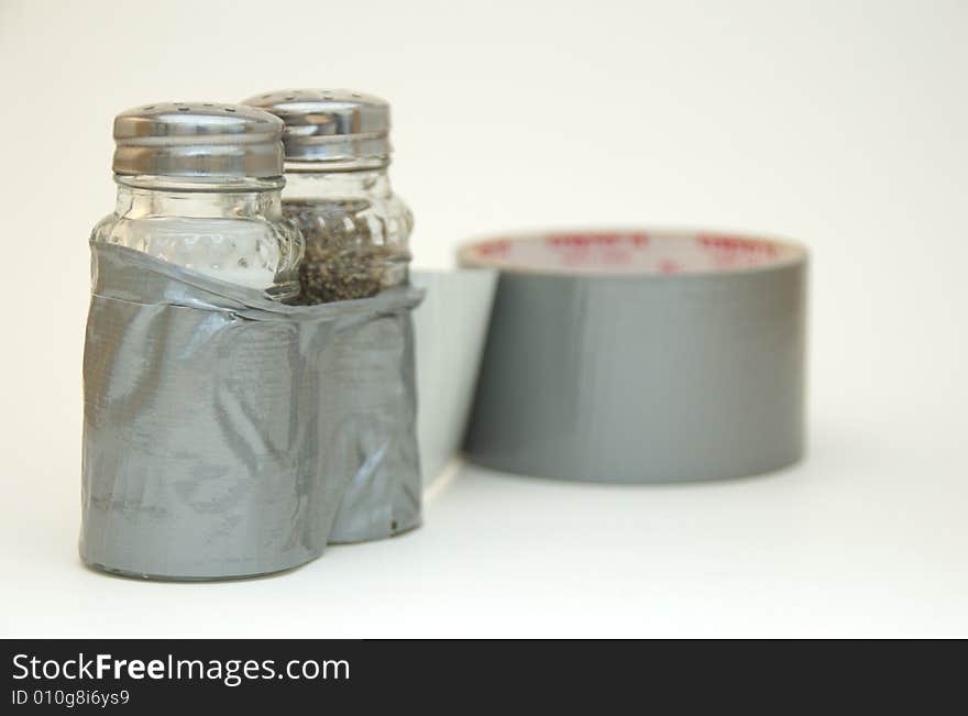 A salt and pepper shaker stuck together with ducttape.  Several concepts including breaking free from ordinary cooking, and more. A salt and pepper shaker stuck together with ducttape.  Several concepts including breaking free from ordinary cooking, and more.