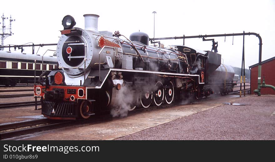 Steam locomotive taking in water