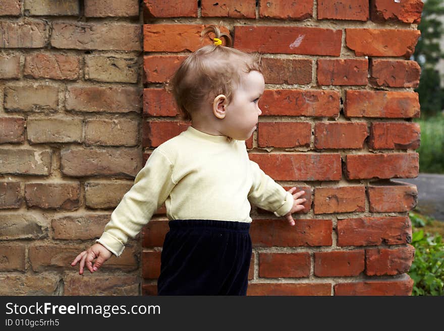 An image of  little girl near a brick wall. An image of  little girl near a brick wall