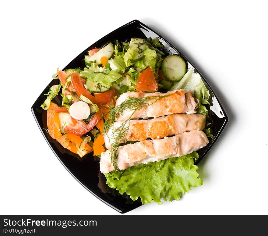 Stake from a salmon with vegetables on a plate. Closeup.