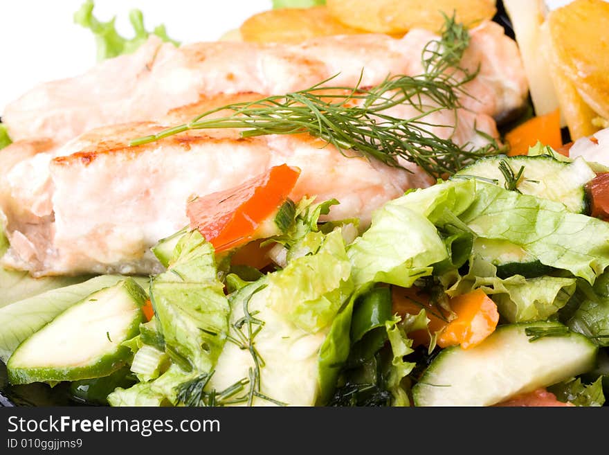 Stake from a salmon with vegetables on a plate. Closeup.