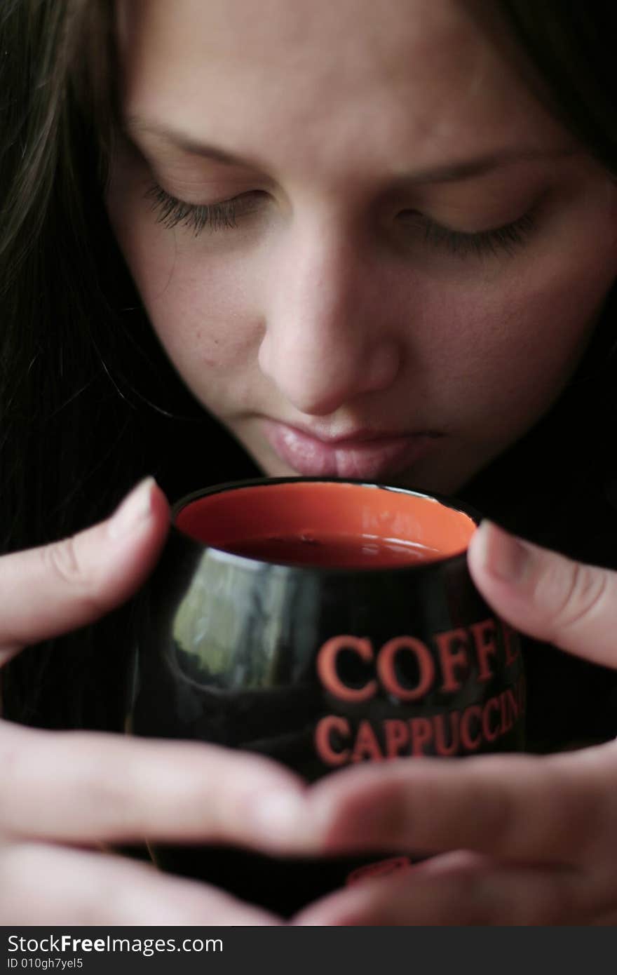 The girl holds in hands a coffee cup