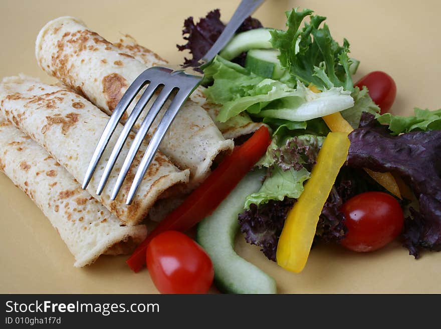 Salad and pancakes with fork