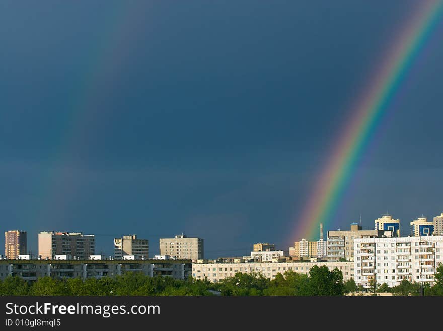 Rainbow on dark stormy sky over city roofs. Rainbow on dark stormy sky over city roofs