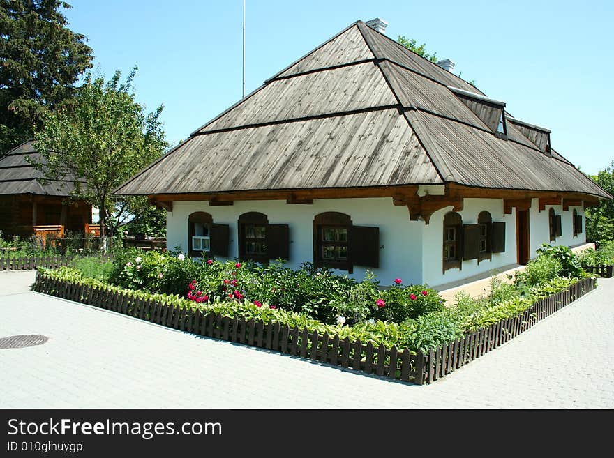 Hata-traditional Ukrainian housing and flowers in front of the windows. Hata-traditional Ukrainian housing and flowers in front of the windows