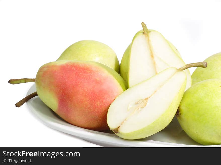 Fresh pears on a plate on bright background. Fresh pears on a plate on bright background