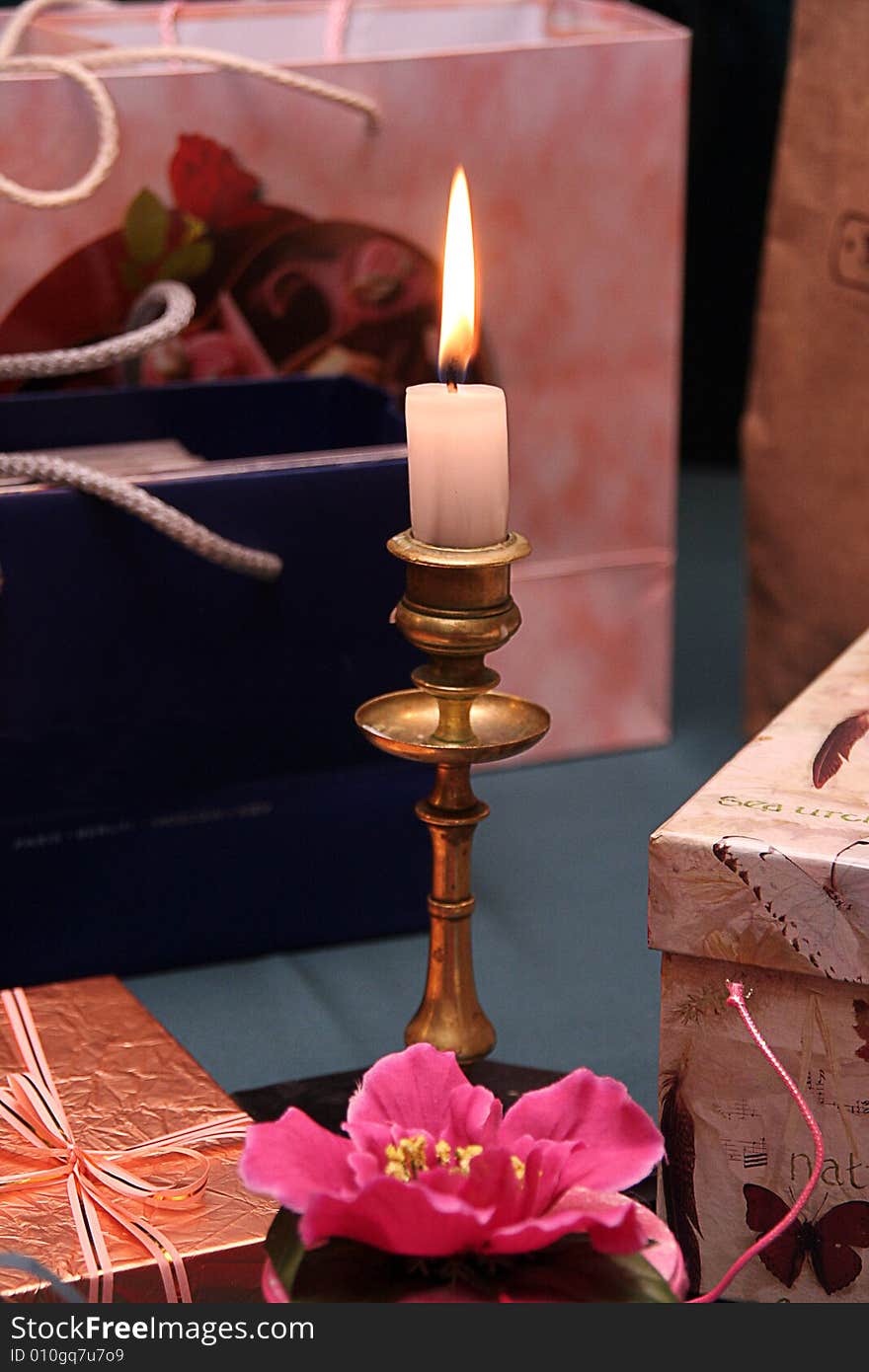 Many gifts and a candle in a candlestick. Many gifts and a candle in a candlestick