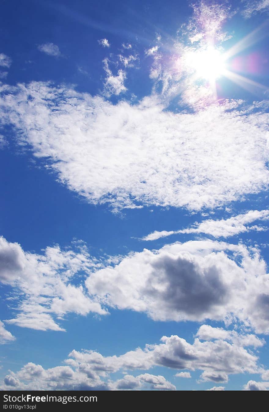 Sun and clouds in a blue sky