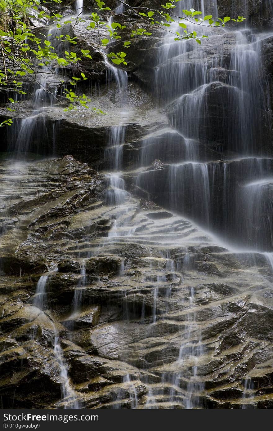 Beautiful waterfall between vegetation and stones